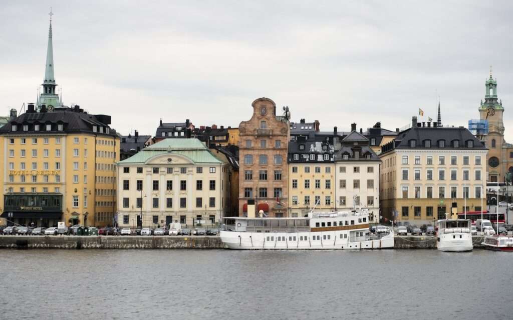 The waterfront facades of Gamla Stan in Stockholm with boats moored along the quay